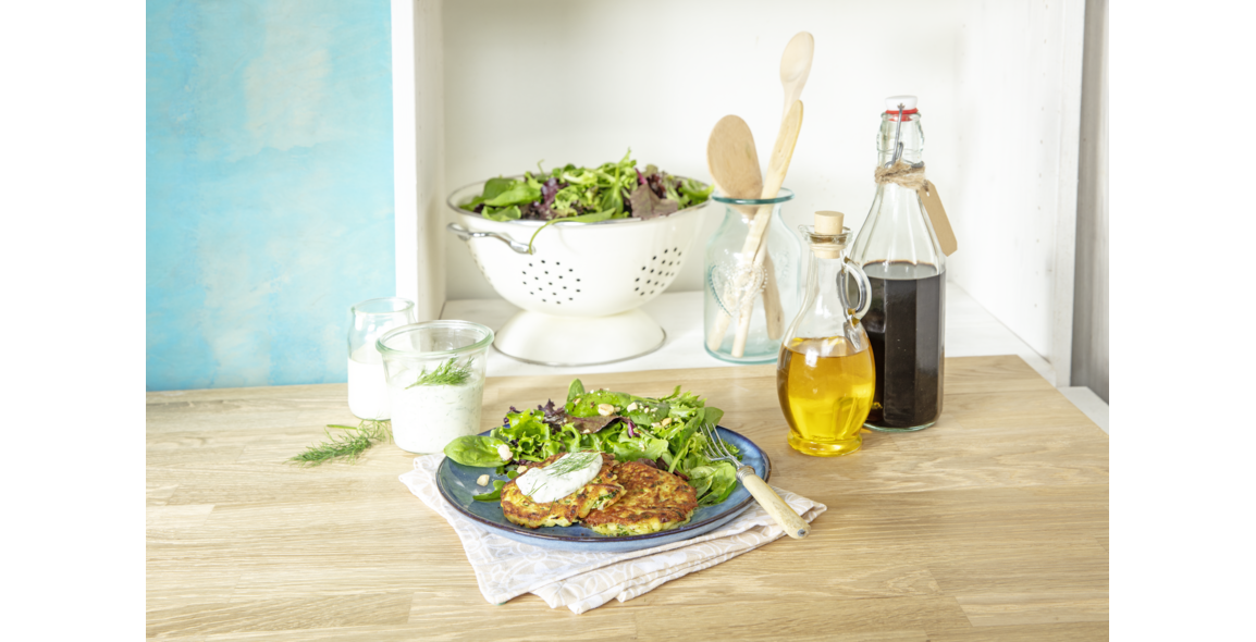Fried potatoe patty on fresh summer salad with cream cheese dip