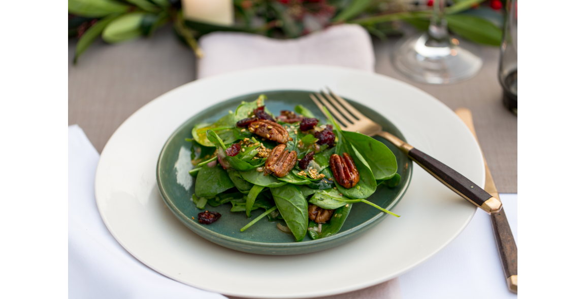 Candied pecan nuts with cranberries on a bed of spinach leaves with a toasted sesame dressing