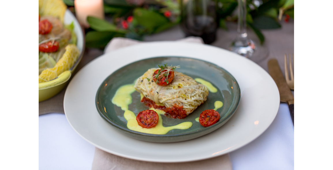 Stuffed savoy cabbage leaves with mushrooms, lentils and rice on tomato sauce and savory almond cream
